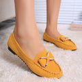 Yellow flat loafers with a metallic bow detail